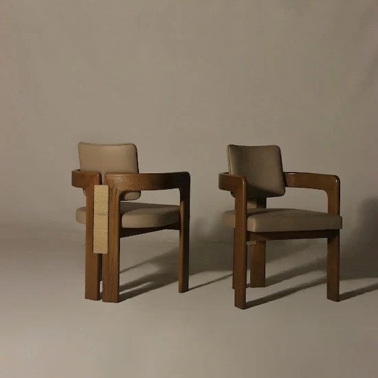 Corset Dining Chair handcrafted from solid wood with upholstered seat and backrest, architectural armrests, woven side detail, and walnut finish.