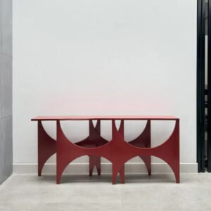 Peer Console handcrafted from solid wood featuring a geometric sculptural pedestal base with semi-circular cut-outs and a matte red finish.
